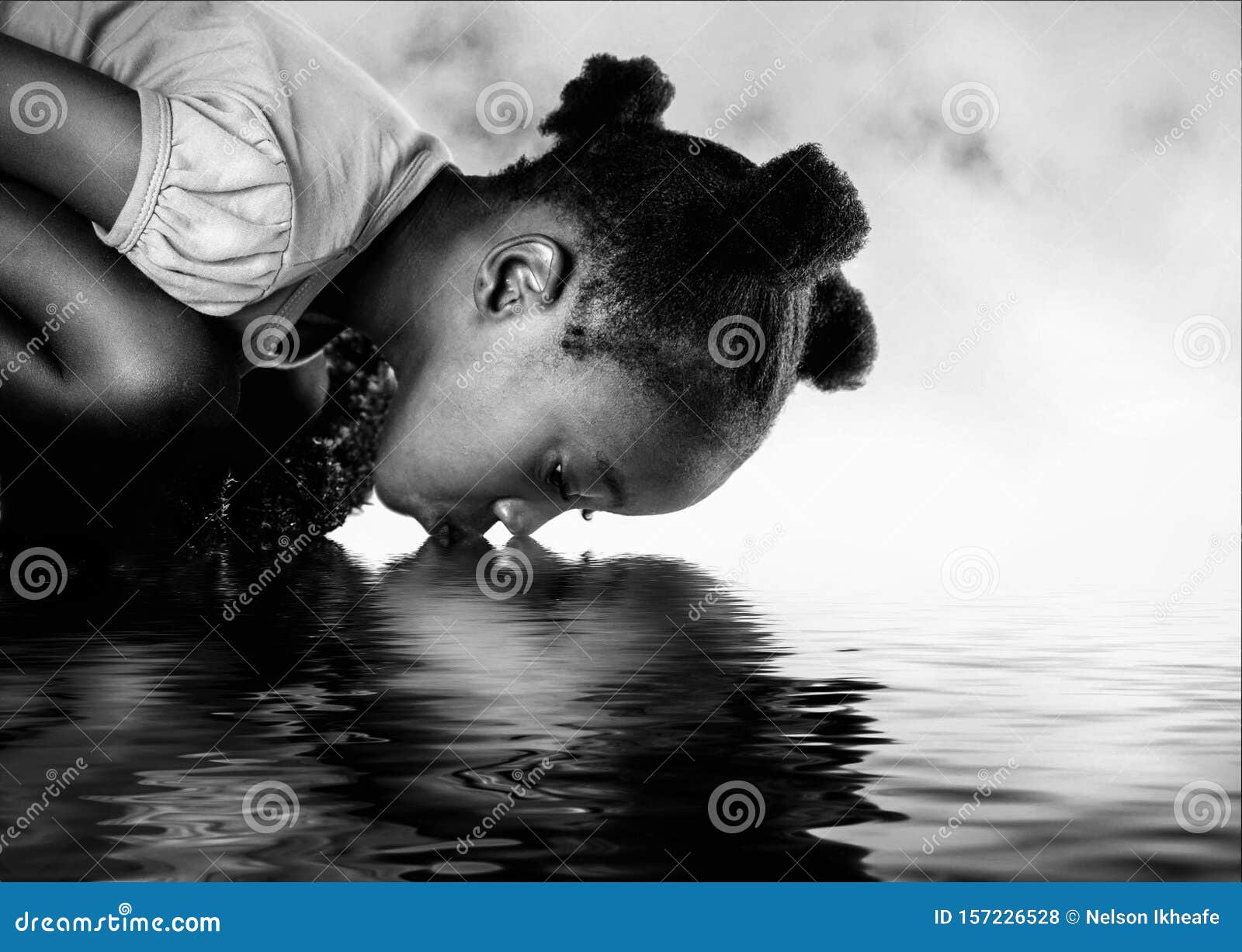 african girl drinking from a river.