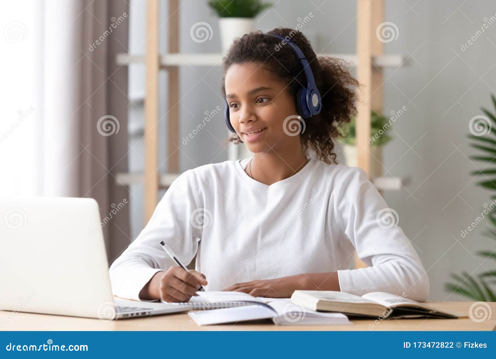 african girl wearing headphones study with skype teacher on laptop