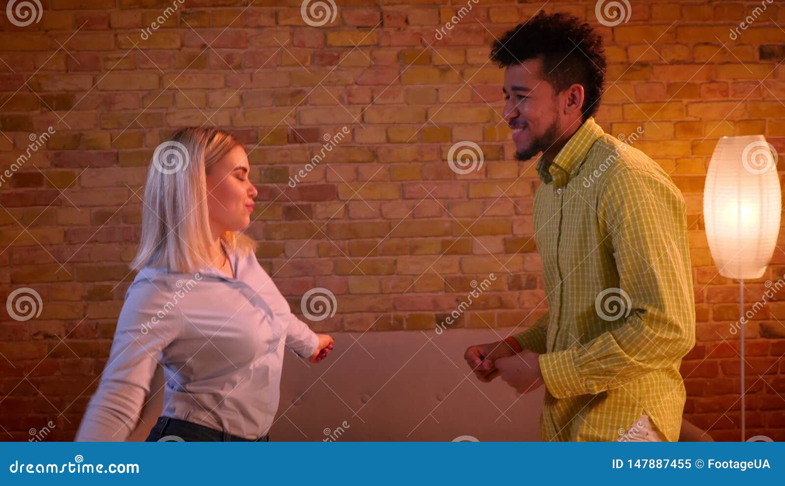 African Guy And Blonde Caucasian Girl Dancing Actively Flirting With