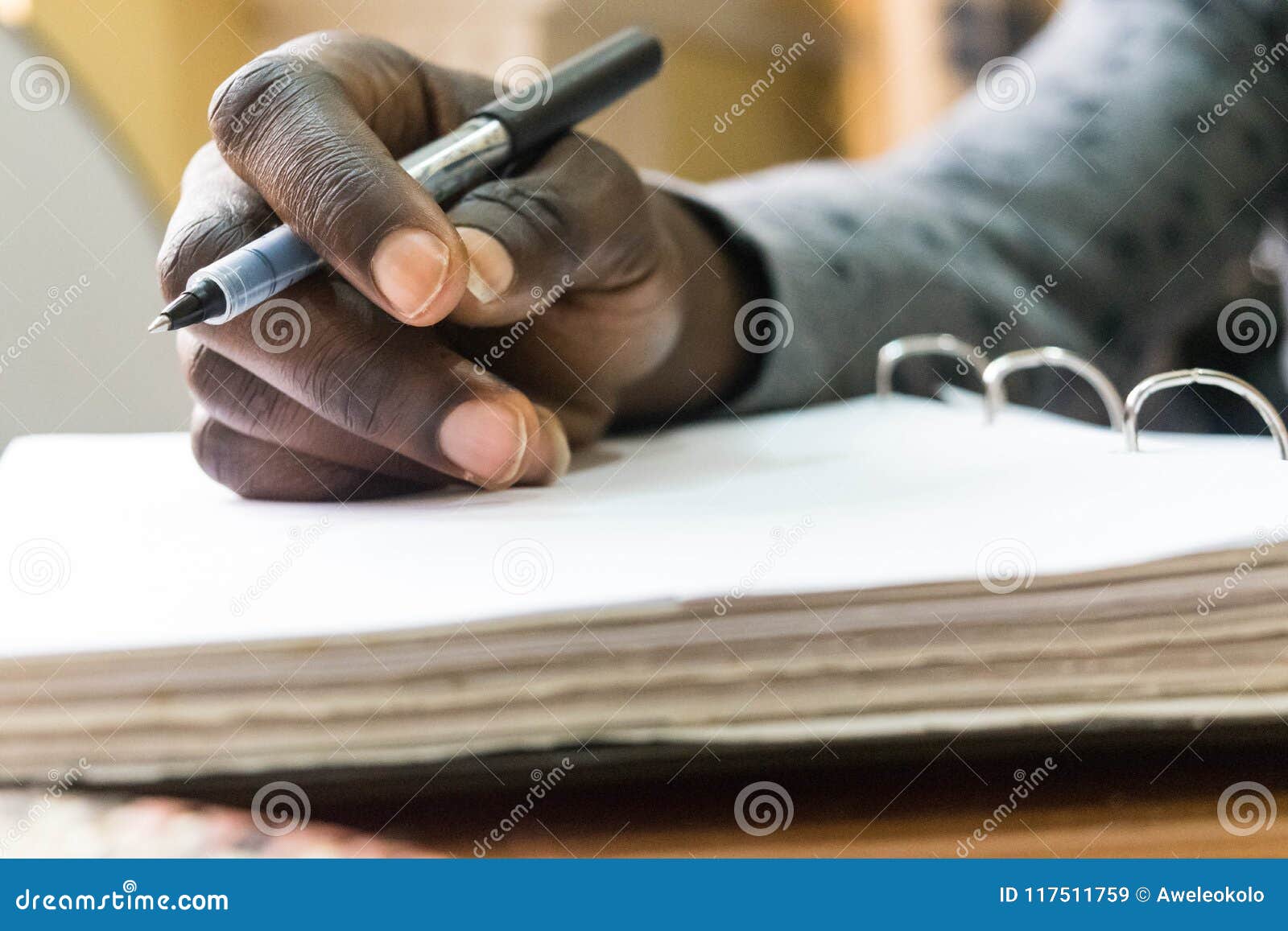 african man holding pen in hand to write on blank white paper