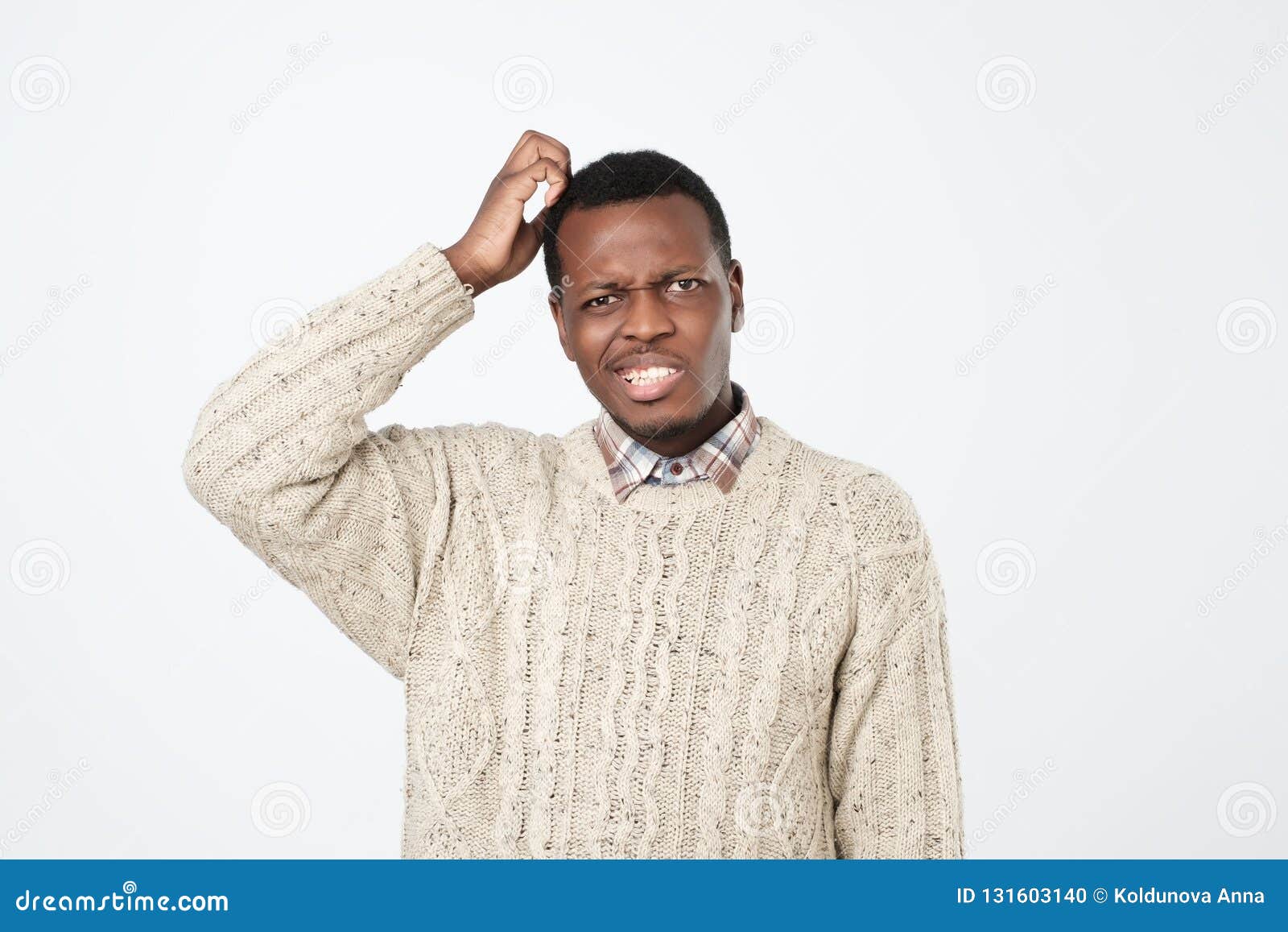 african man in sweater thinking scratching head on white background. how is it supposed to be done concept