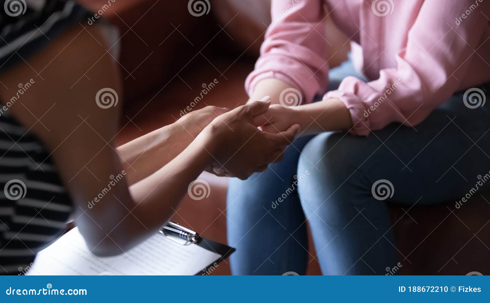 african psychologist holds hands of girl patient, closeup view
