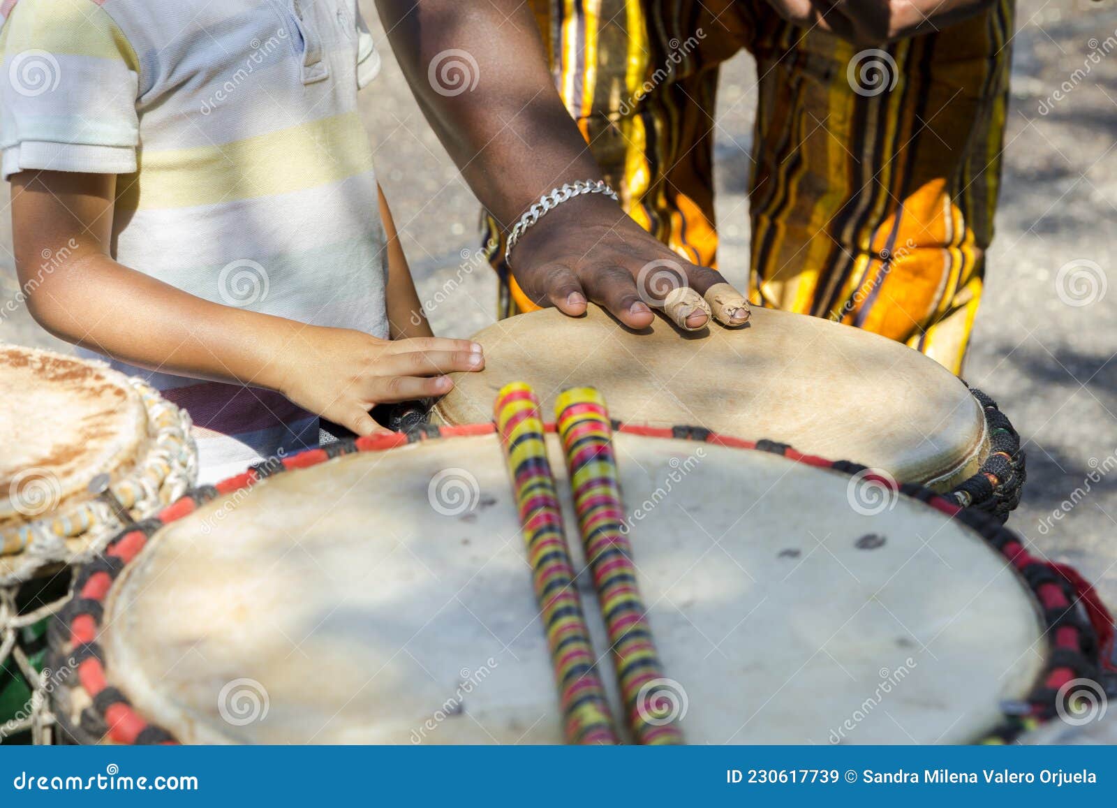 African Teaching a Latino Child about African Instruments Stock Image ...