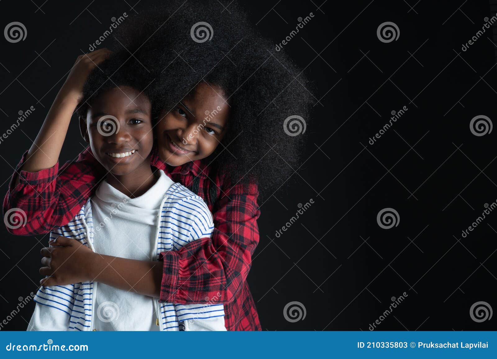 african teen siblings boy and girl hugging with smiley face on black background