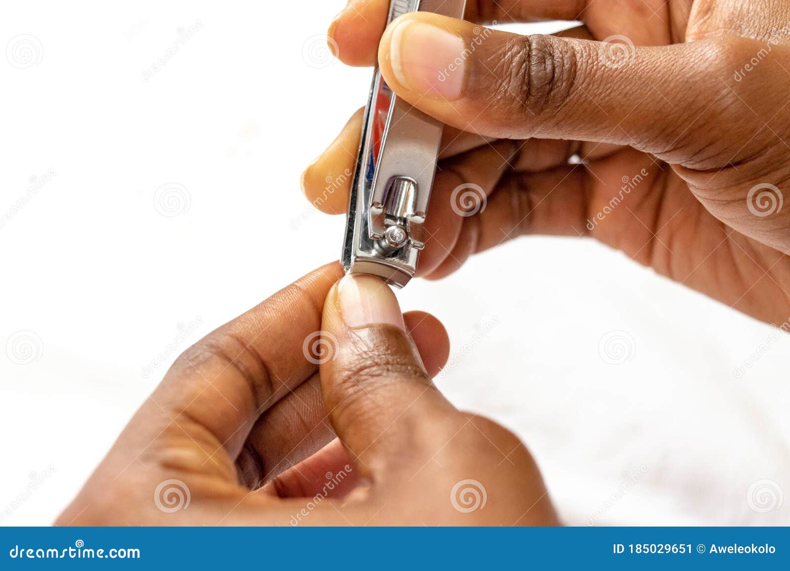 african woman`s hand with healthy natural nails getting nail care procedure. black female hands removing cuticles