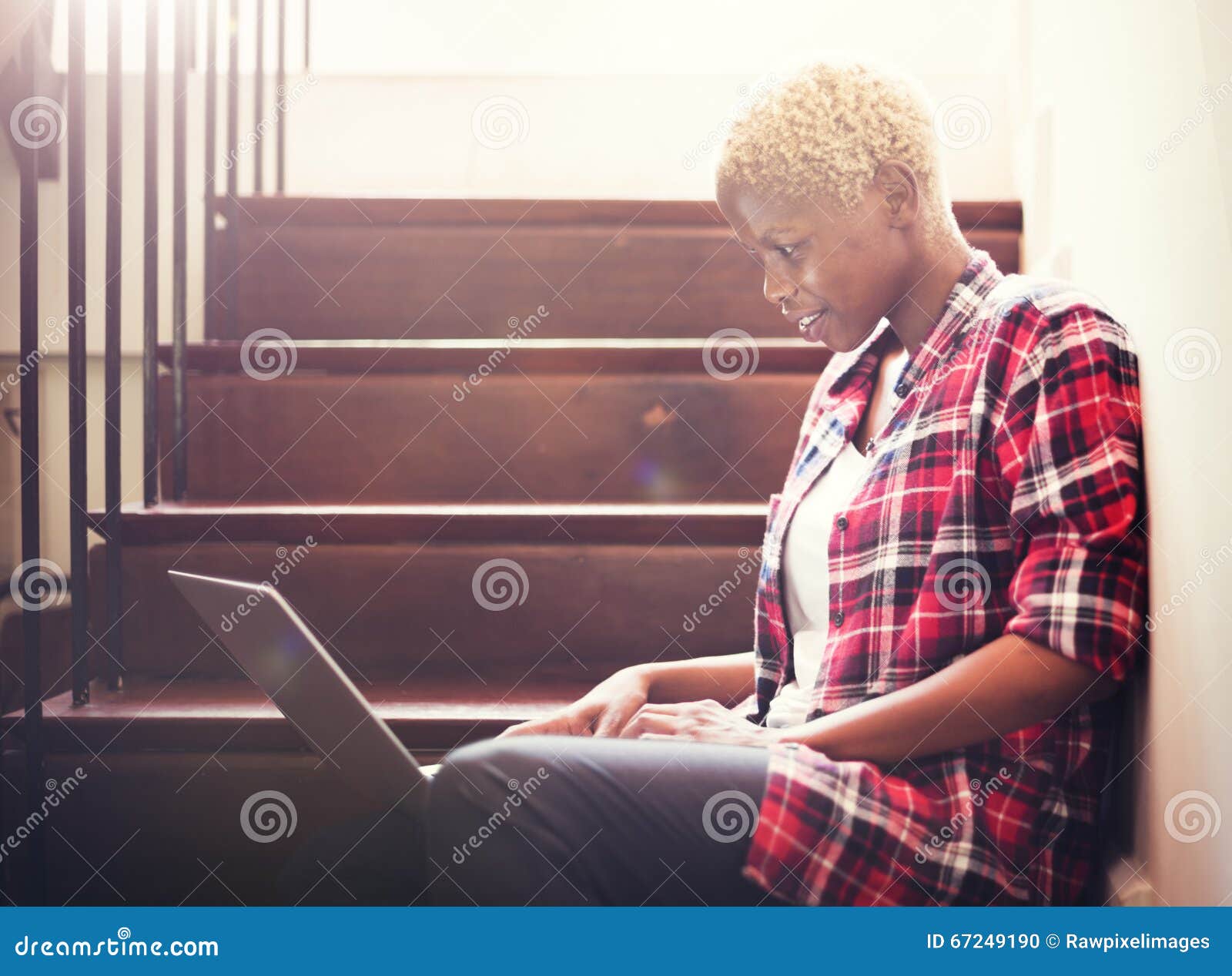 african woman searching internet sitting on steps