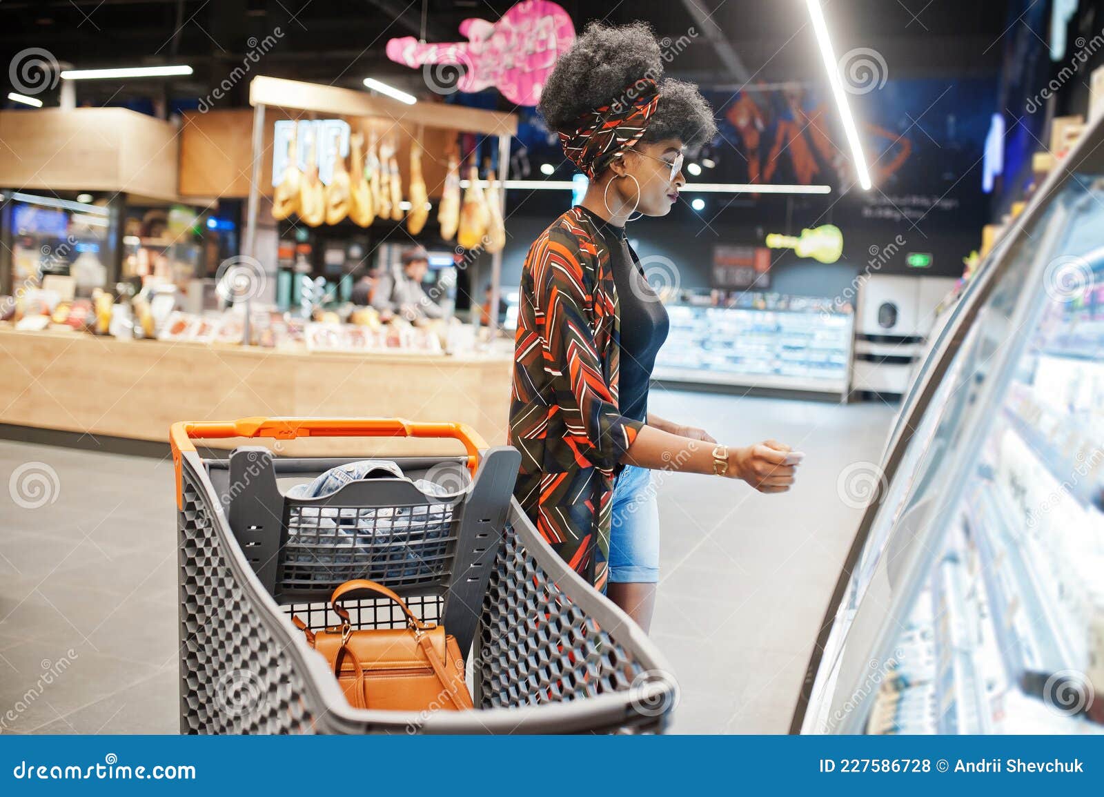 African Woman with Shopping Cart Choose Yogurt Bottle from Fridge at ...