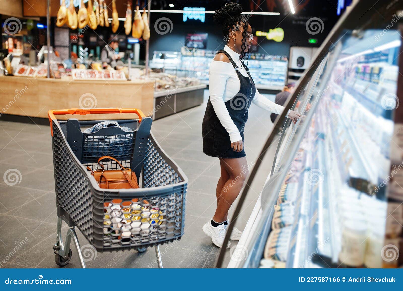 African Woman with Shopping Cart Choose Yogurt Bottle from Fridge at ...