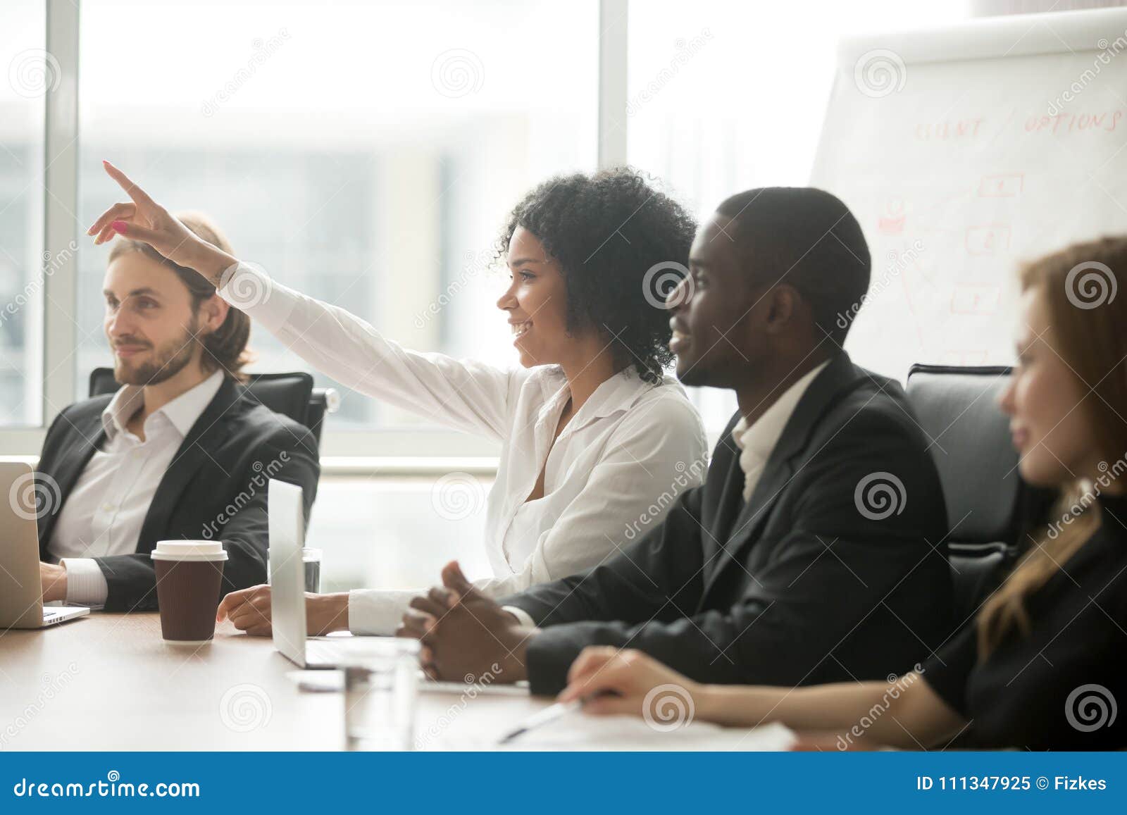 african woman raising hand to ask question at team training