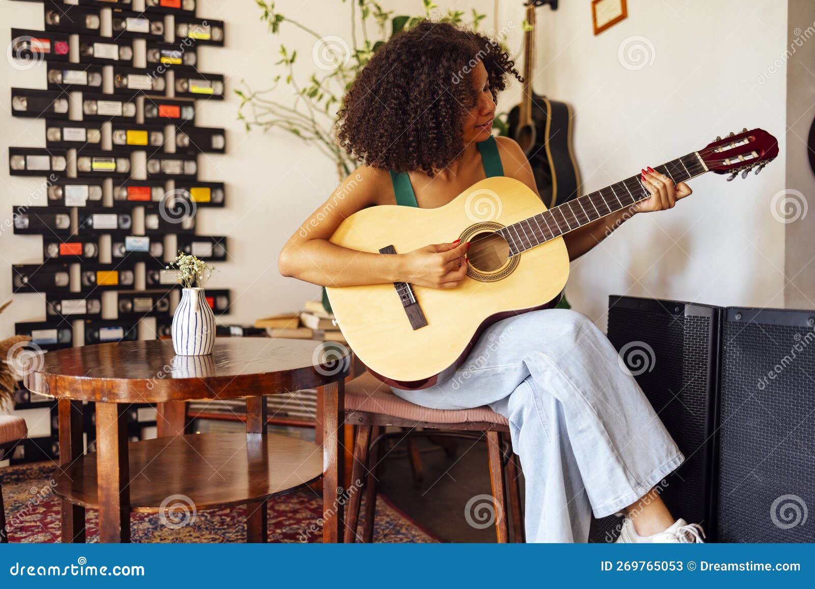 afro americal young woman playing acoustic guitar
