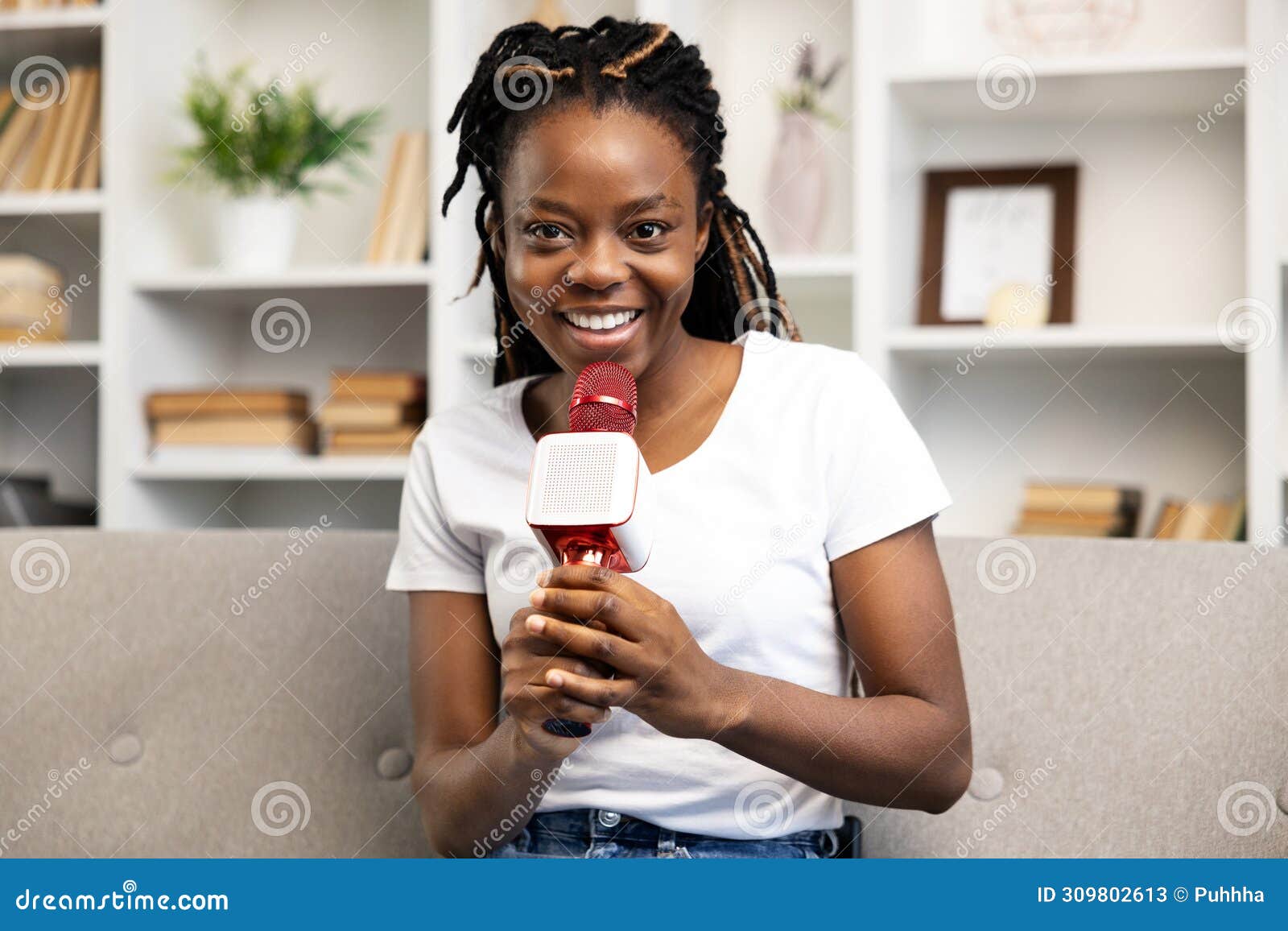 afro american woman enjoying podcasting with microphone at home