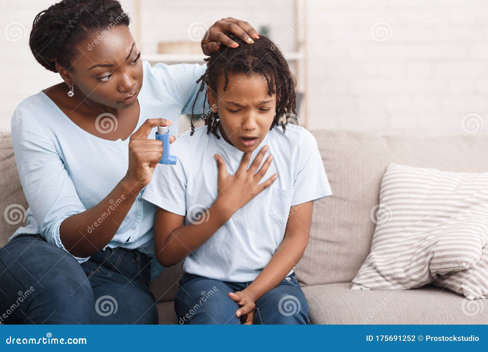 afro mother holding asthma inhaler for daughter