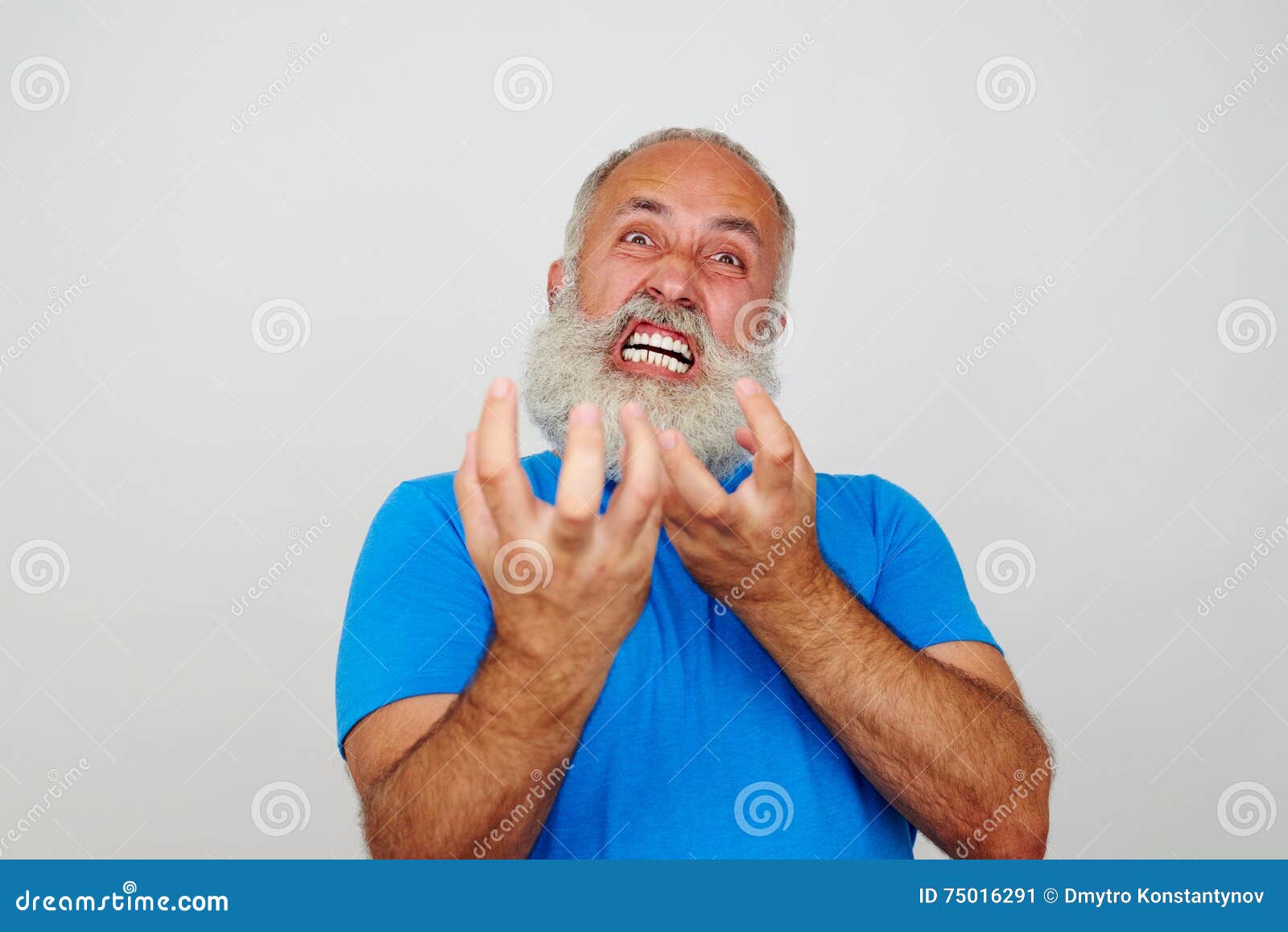 aged bearded man grimacing at the camera expressing extreme nervousness