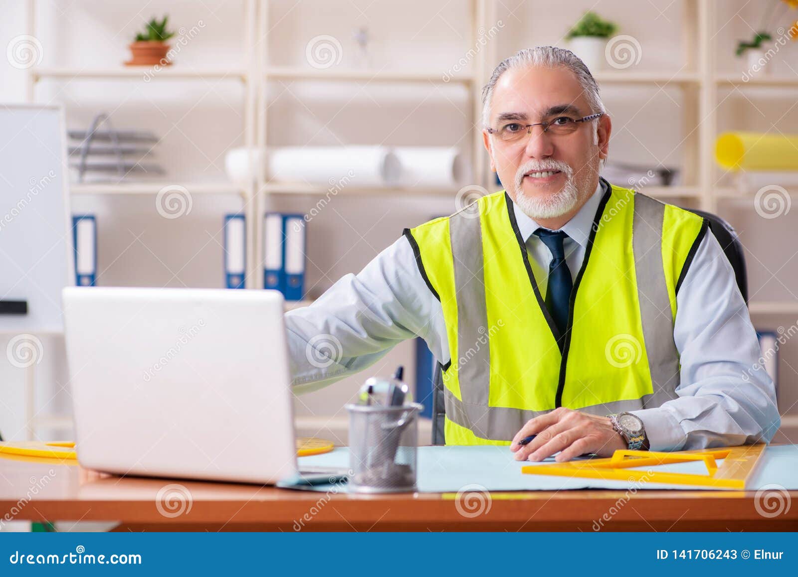 The Aged Construction Engineer Working in the Office Stock Image