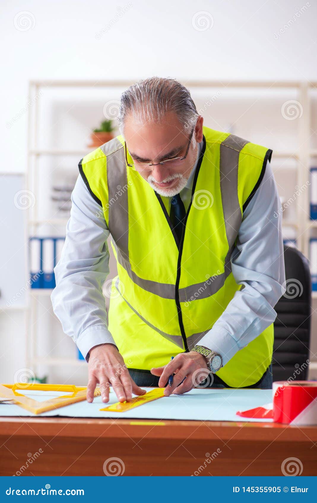 The Aged Construction Engineer Working in the Office Stock Image