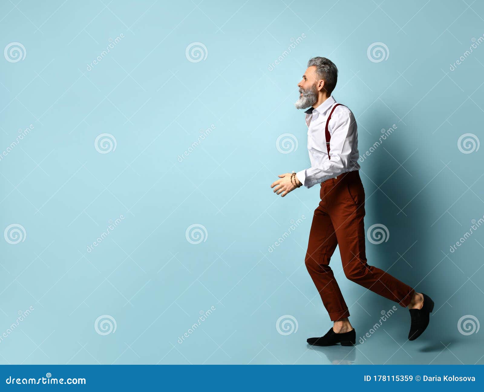 Aged Male in White Shirt, Brown Pants and Suspenders, Black Loafers. he is  Showing Thumbs Up, Walking on Blue Studio Background Stock Image - Image of  businessman, male: 177956047