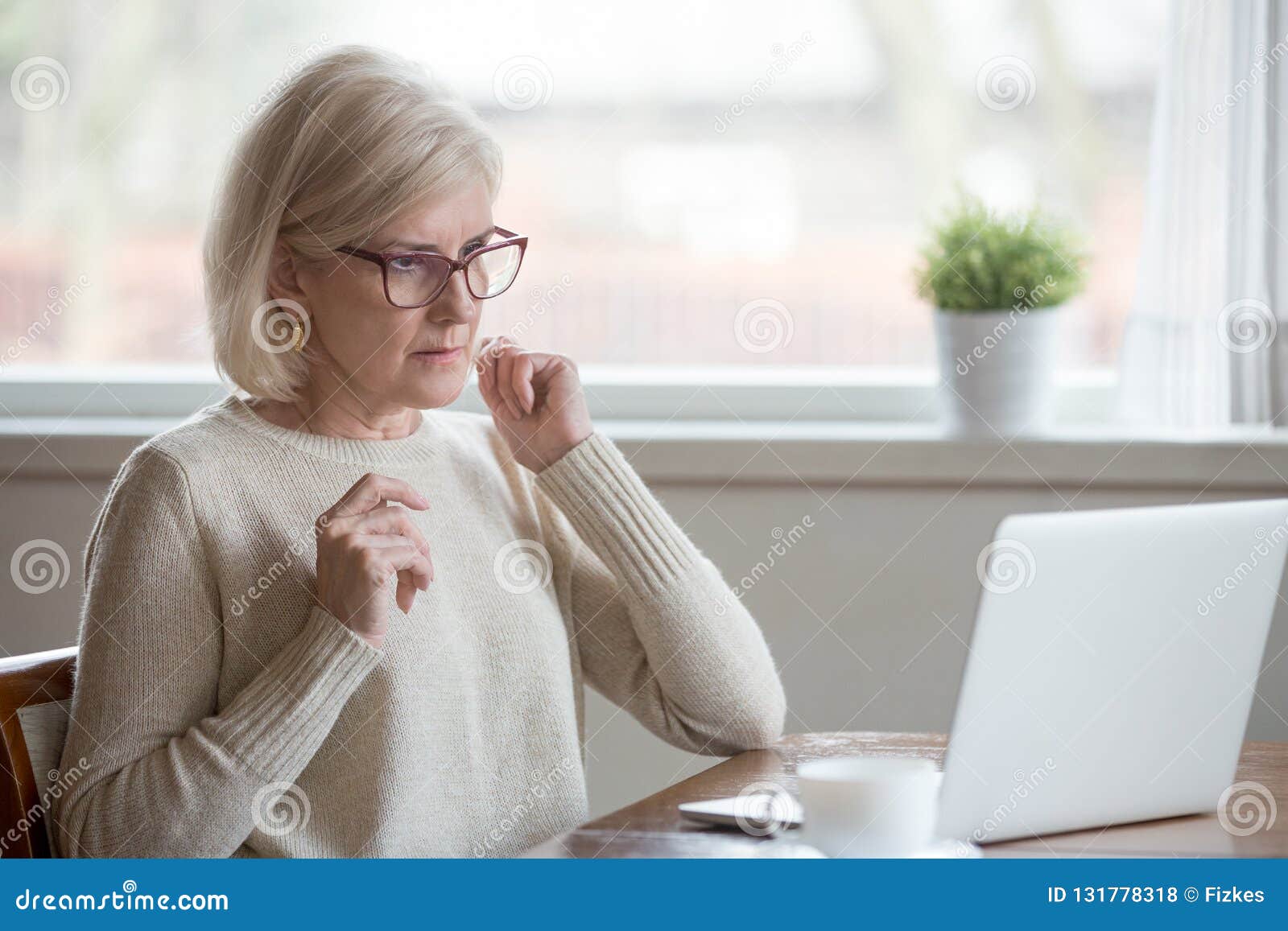 aged woman using laptop confused seeing error message