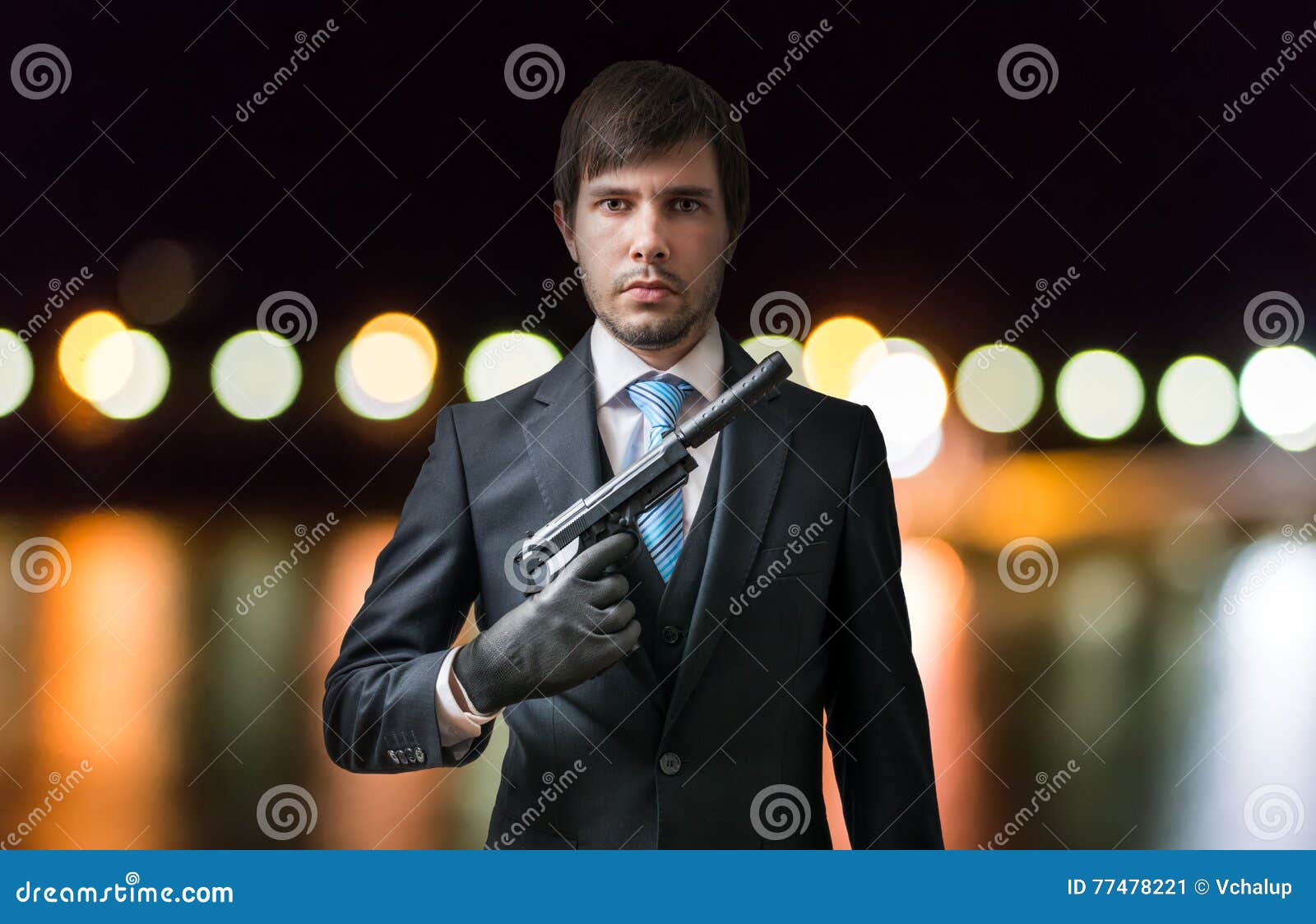 Agent or Spy Holds Pistol in Hand at Night. Blurred Lights in