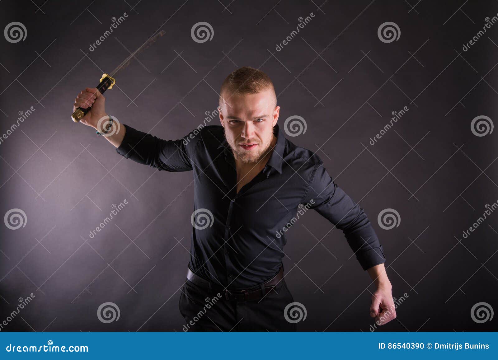 Aggressive Young Man Holding Katana Sword Looking at the Camera.Against ...