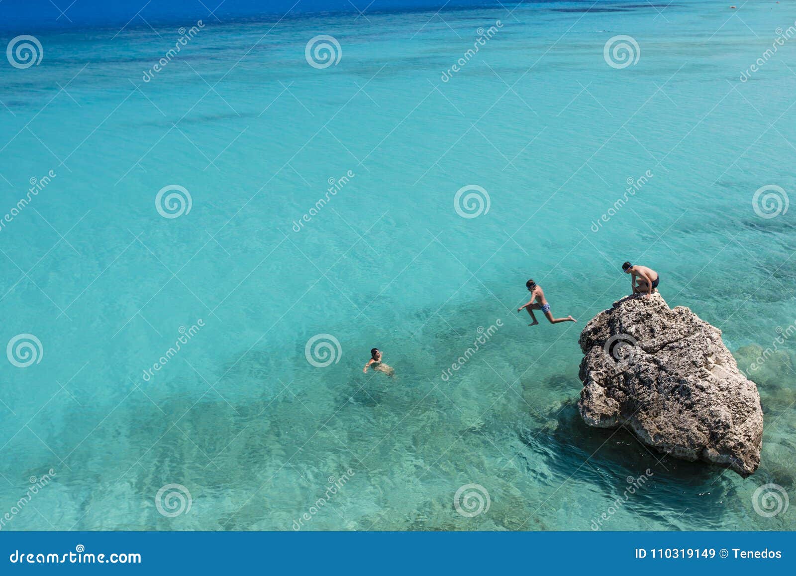 Jumping into Turquoise Waters of Agios Ioannis Beach at Lefkada, Greece ...