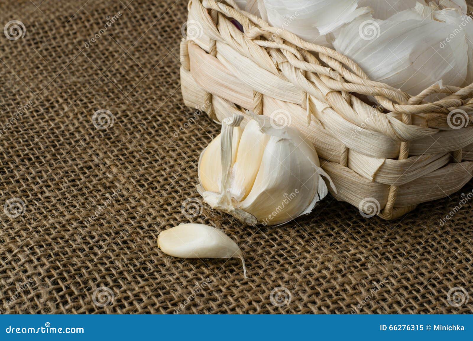 Aglio in un piccolo cestino. Aglio in un piccolo canestro sulla fine della tovaglia della iuta su, spazio per testo