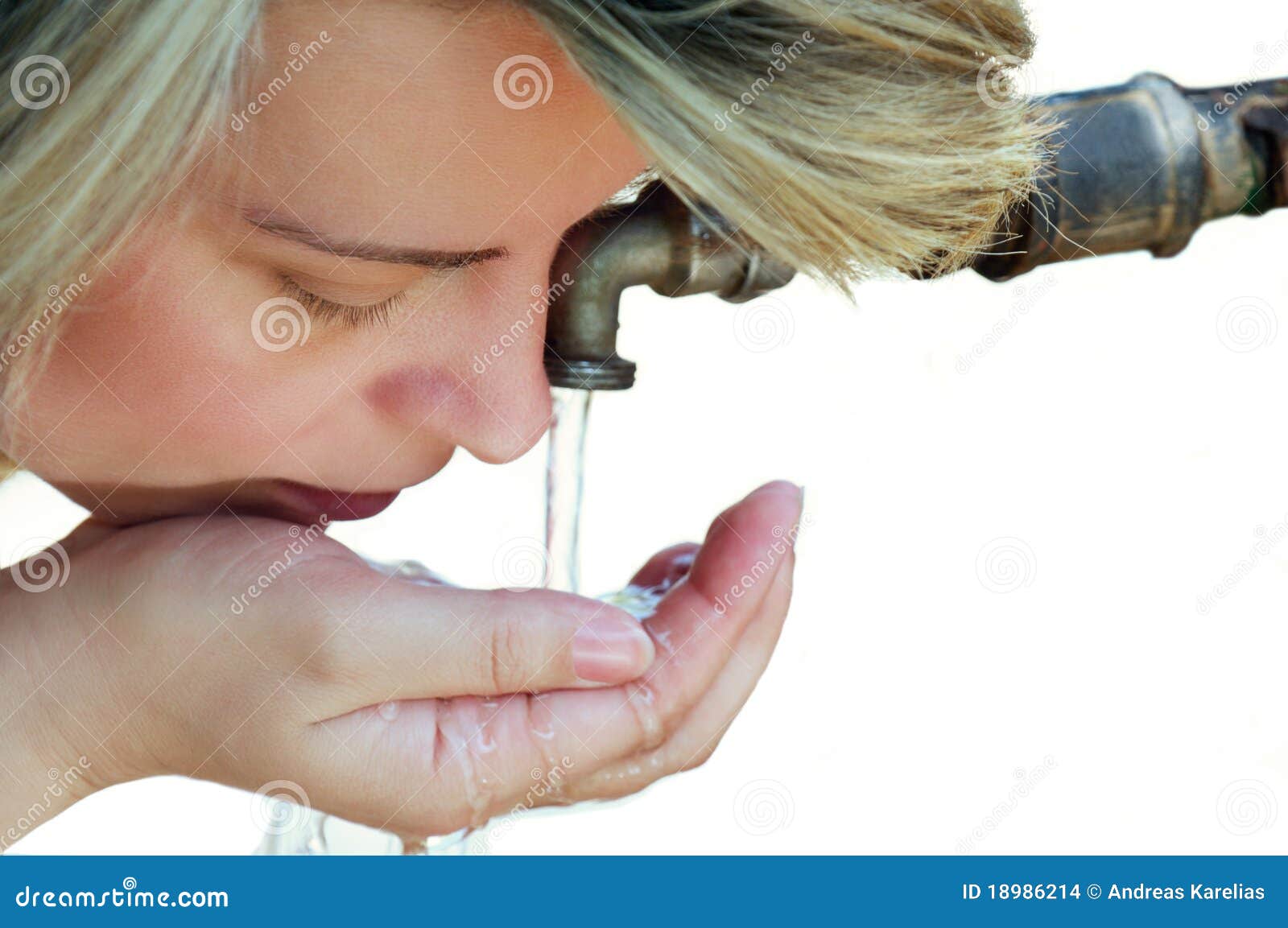 Agua potable de la mujer hermosa del golpecito. Agua potable rubia hermosa de la mujer joven de un golpecito usando su mano. Aislado contra el fondo blanco