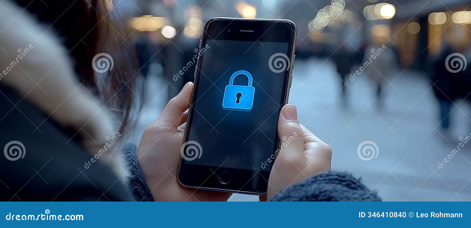 close up of a smartphone displaying a glowing padlock icon, held outdoors in a busy urban street setting, izing data secu