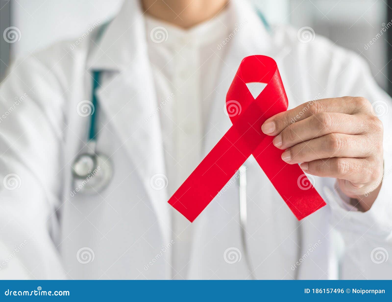 aids red ribbon in doctorÃ¢â¬â¢s hand for world aids dayand hiv virus awareness concept