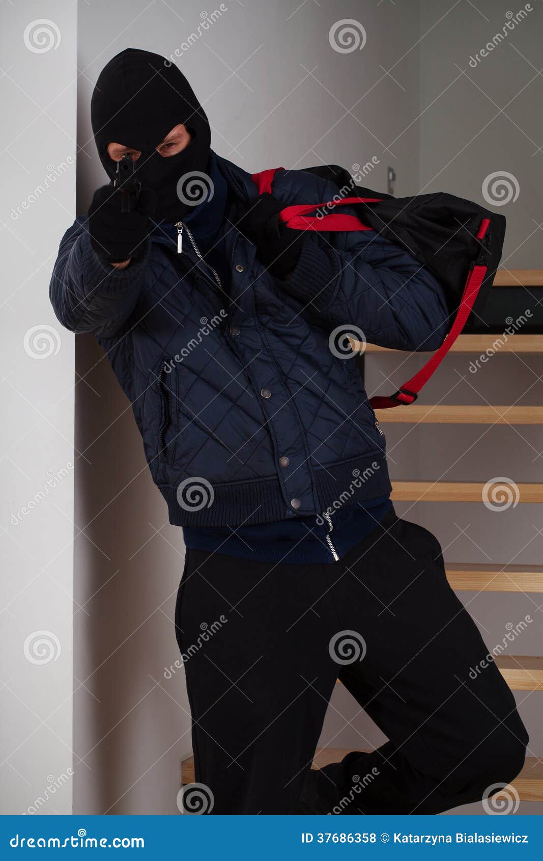 Robbery in store. Robber is aiming and threatening with gun in shop. Stock  Photo