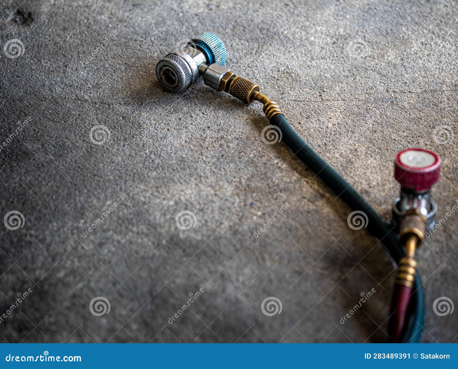 Air Conditioner Charging Hose on the Rough Concrete Flooring Stock