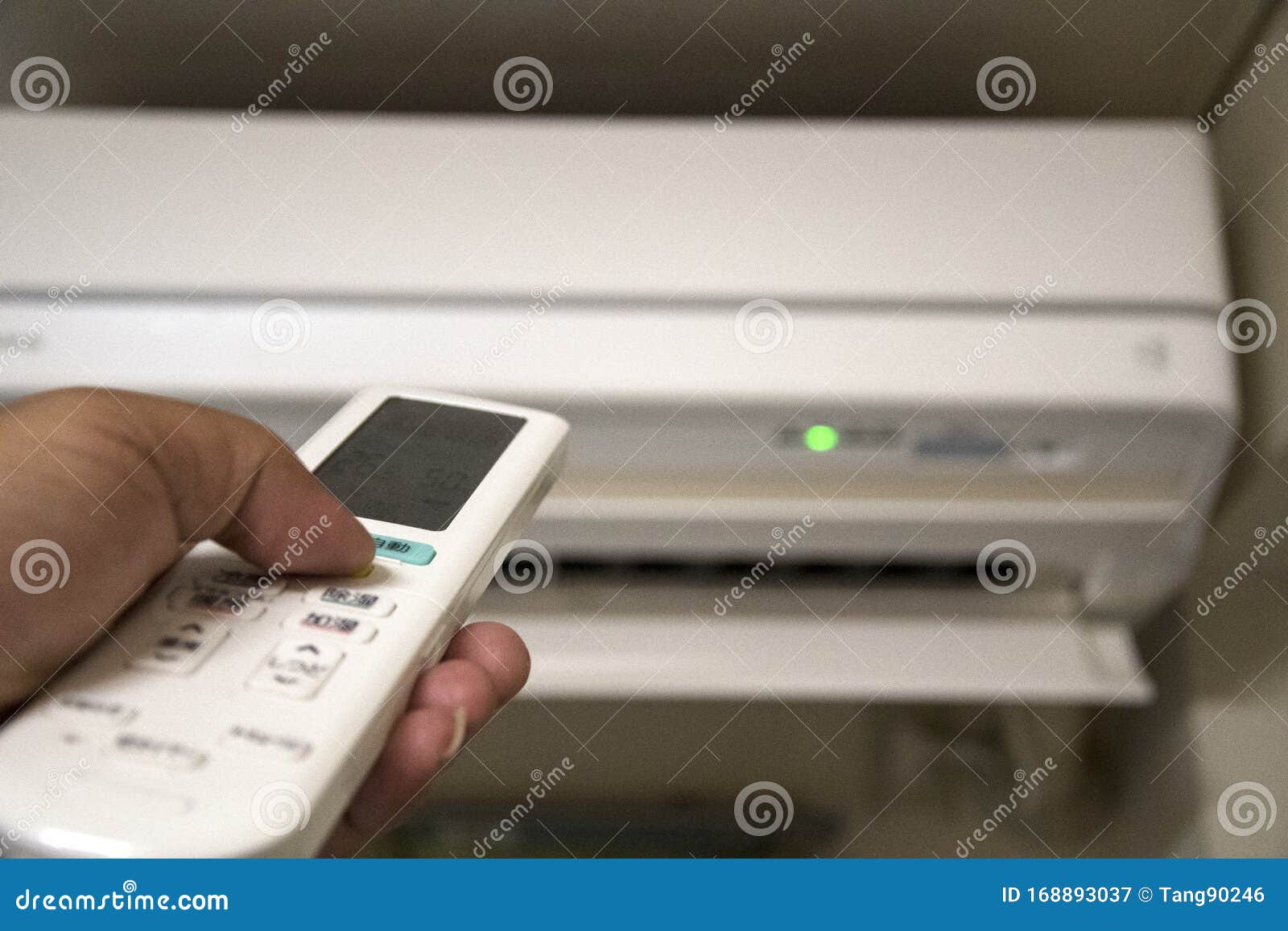 air conditioner with left aligned hand operating remote control