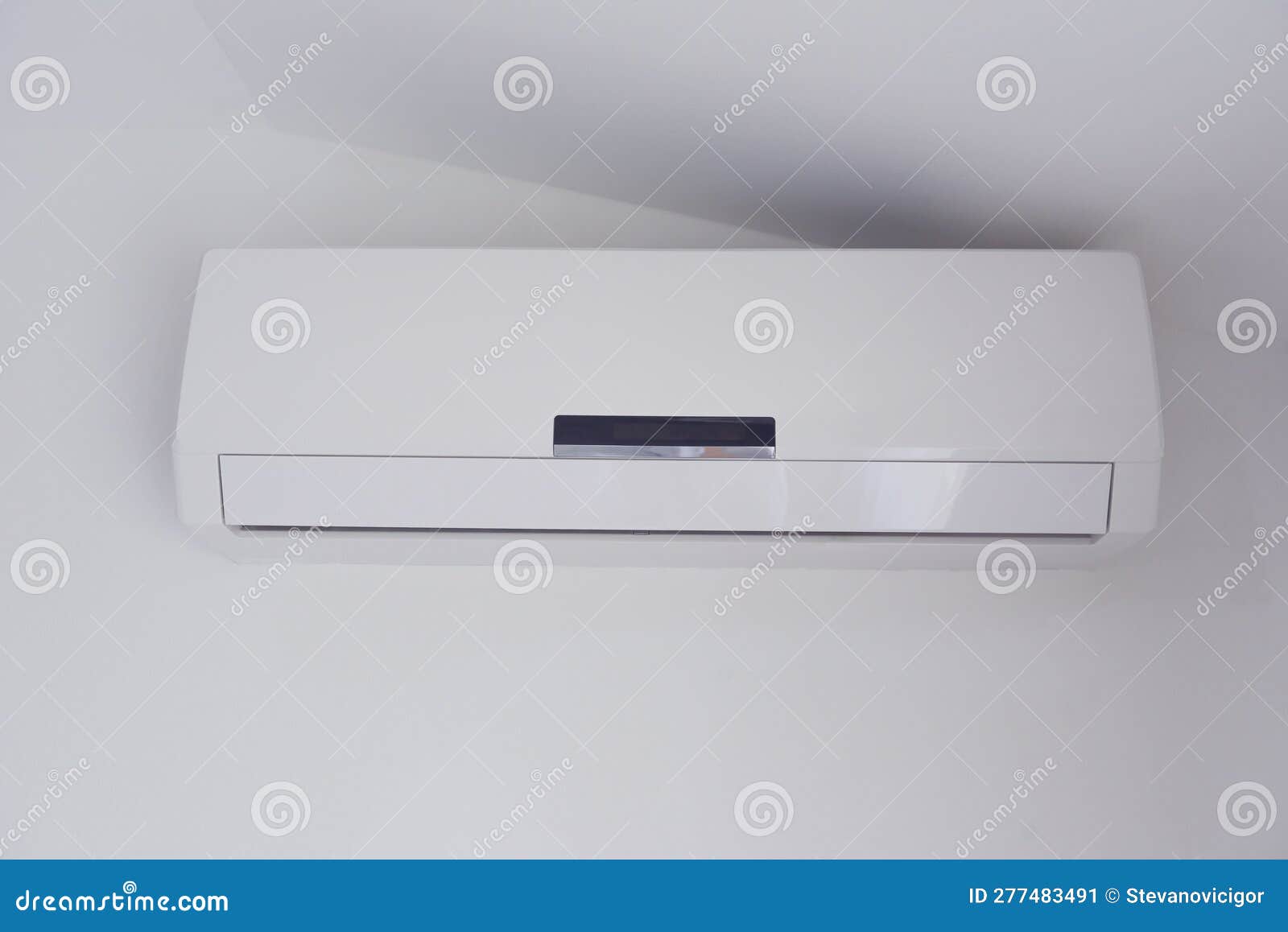 Air Conditioner Mounted on a White Wall of Apartment Bedroom Stock