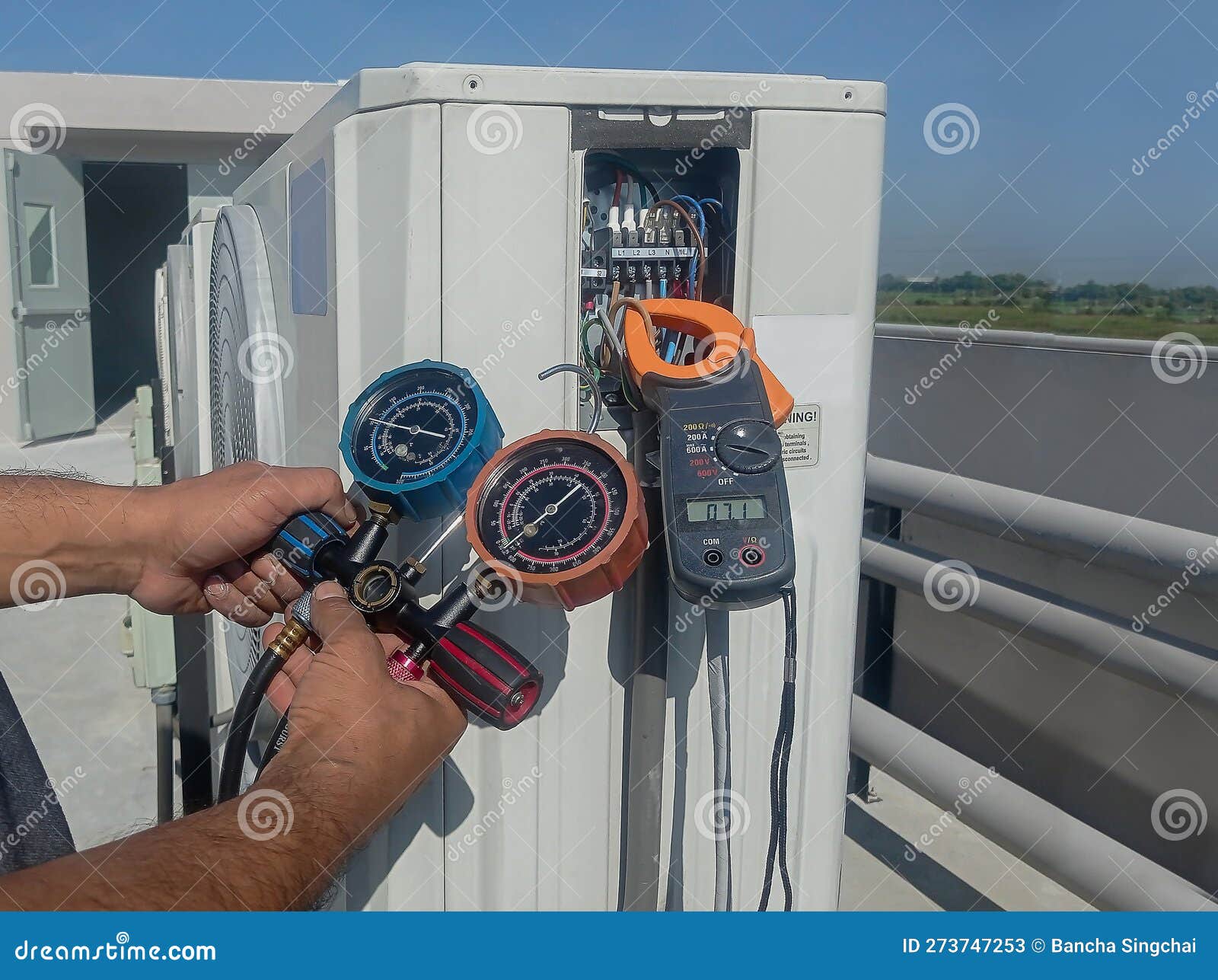 air repair mechanic using measuring equipment for filling industrial factory air conditioners.