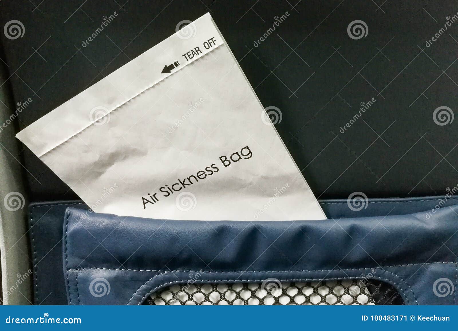 air sickness bag tucked behind airplane seat pocket