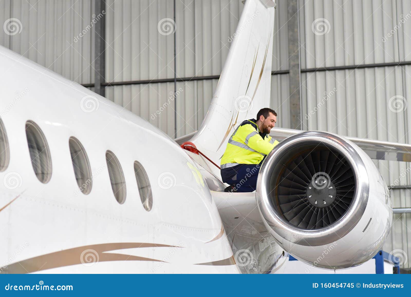 aircraft mechanic inspects and checks the technology of a jet in a hangar at the airport