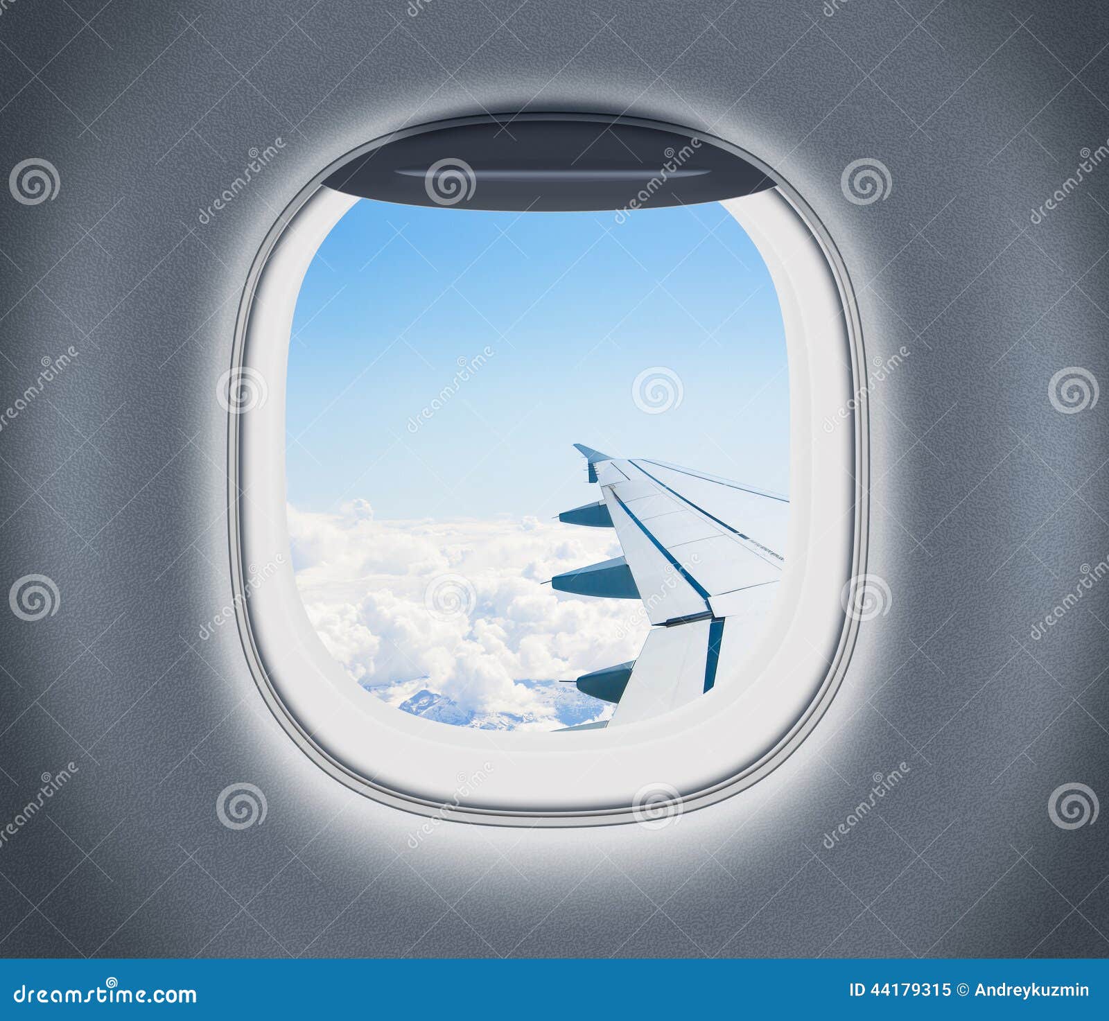 airplane or aeroplane window with wing and cloudy sky behind