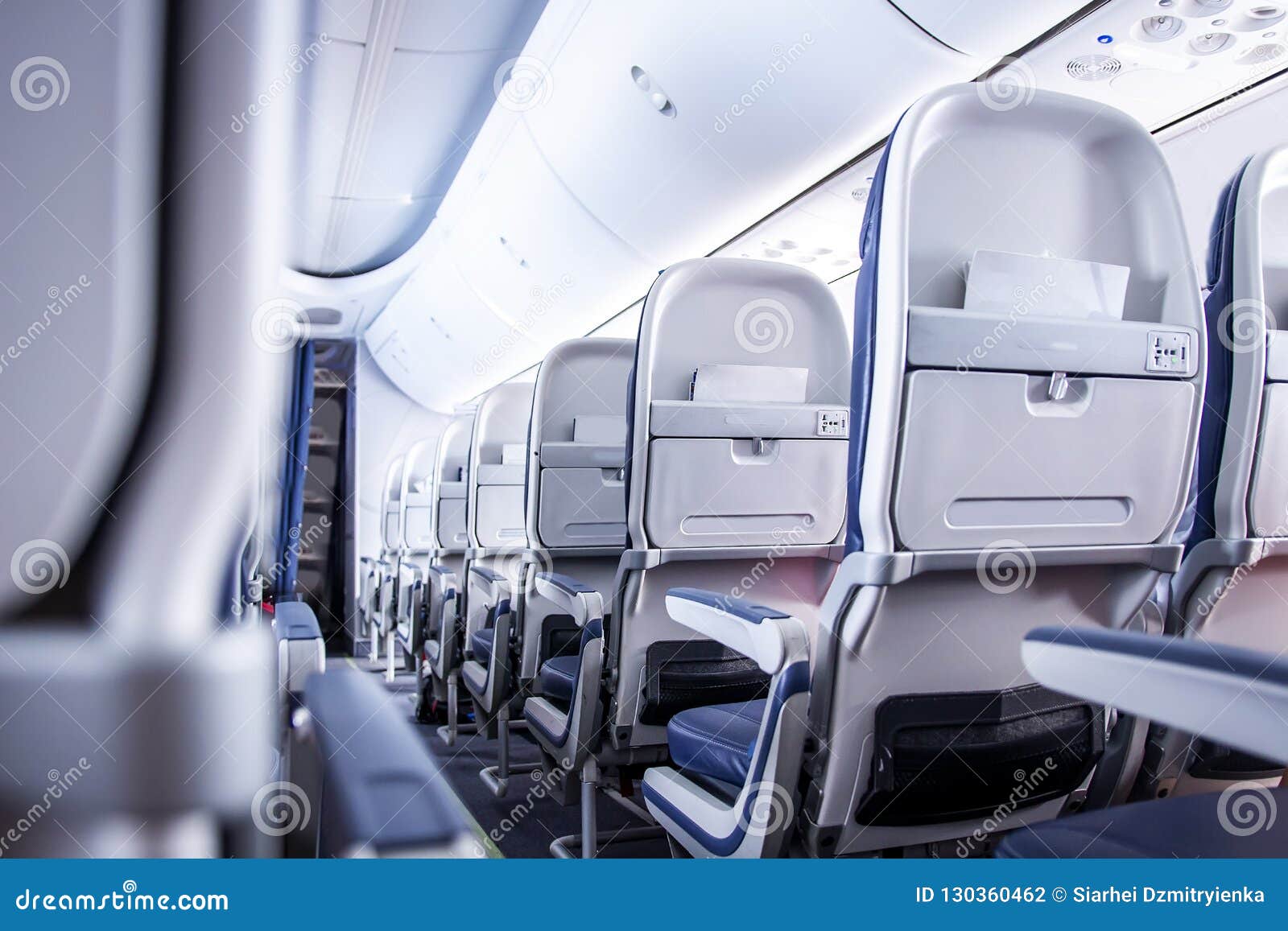 airplane seats in cabin. commercial aircraft cabin with rows of seats down the aisle. economy class.