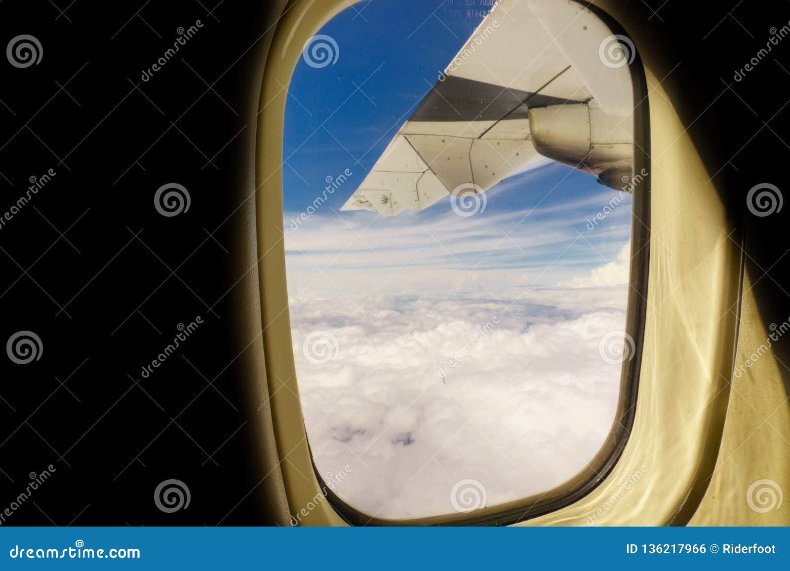 airplane transport concept. view on the left wing passenger aircraft.below the thick clouds illuminated by the sun.horizontal view