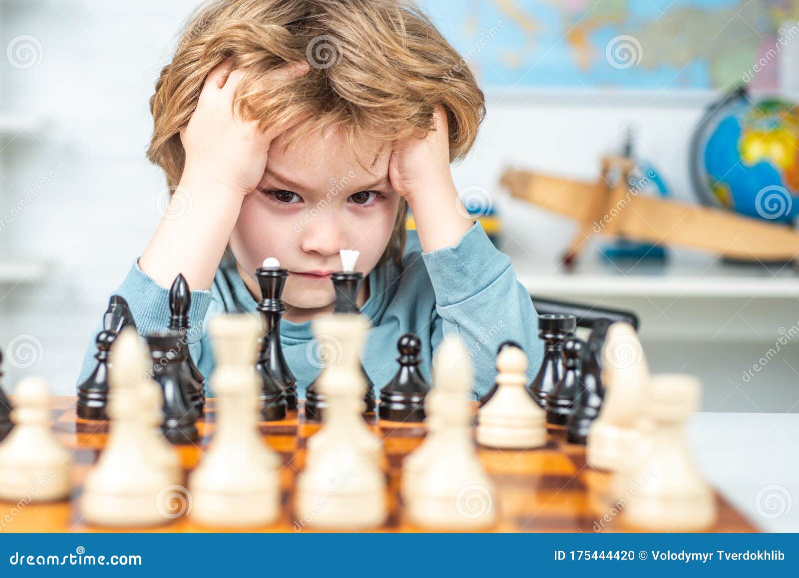Chico inteligente aprende a jugar al ajedrez solo en su habitación en casa