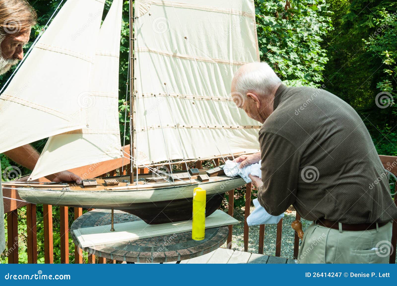 Aktiv gammalare man och Son med det Model fartyget. Fungerar gammalare män samman med hans vuxna son på en model segelbåt.