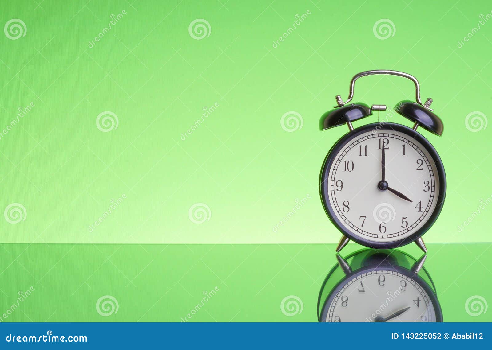 alarm clock on green background with selective focus and crop fragmen