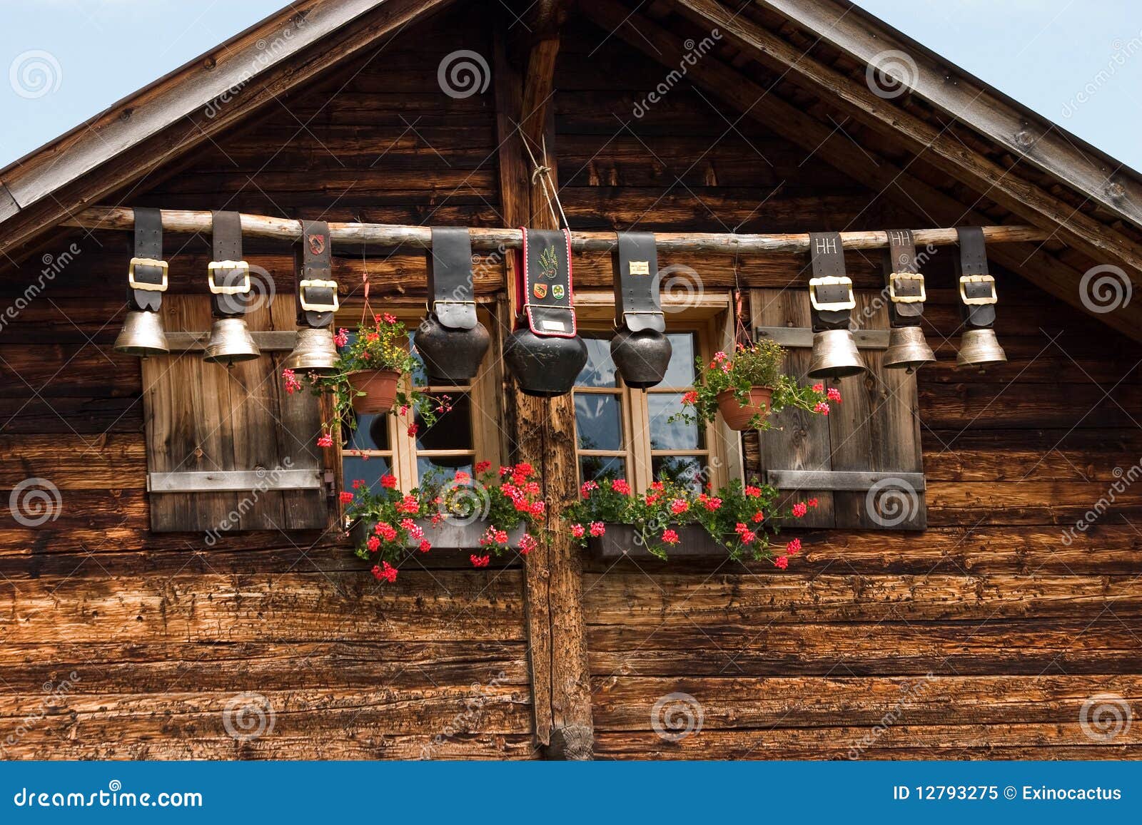 Alarmas decorativas de la vaca bajo la azotea de la choza del mounain