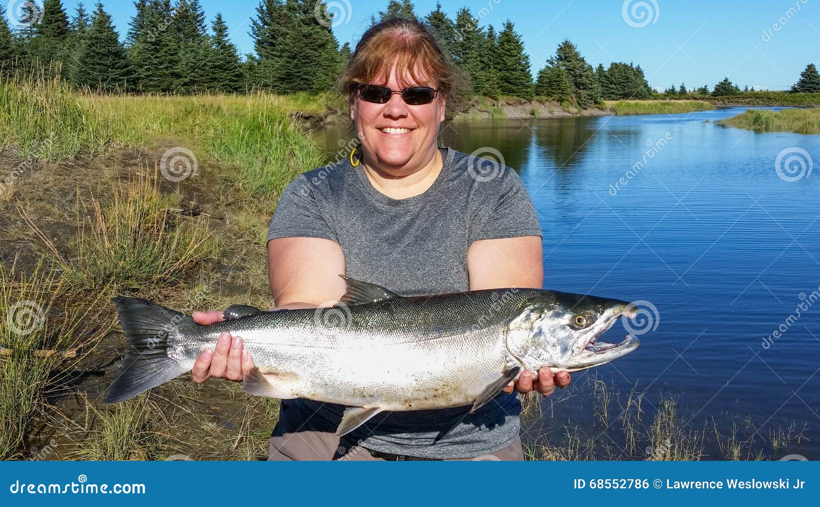 alaska woman holding silver salmon lake clark national park