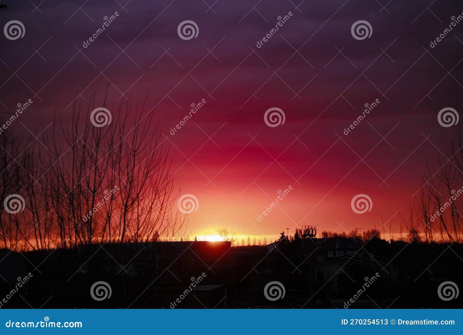 alba - cielo con sfumatura da arancio a blu in un'atmosfera suggestiva con silhouette di edifici e alberi in controluce