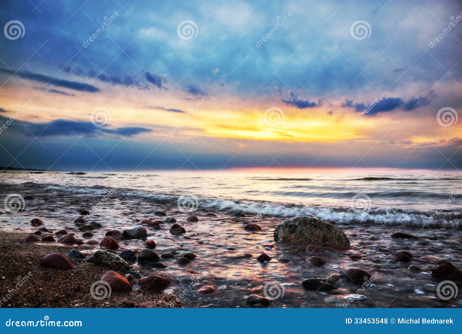 Alba drammatica su una spiaggia rocciosa. Mar Baltico. Alba variopinta drammatica su una spiaggia rocciosa. Mar Baltico