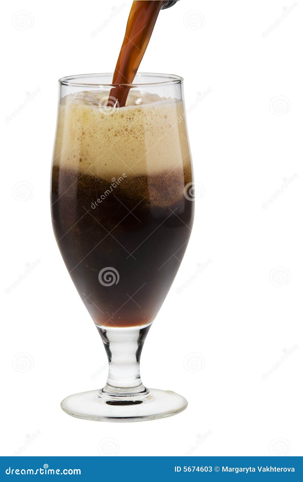 alcohol dark beer with froth pouring into a glass