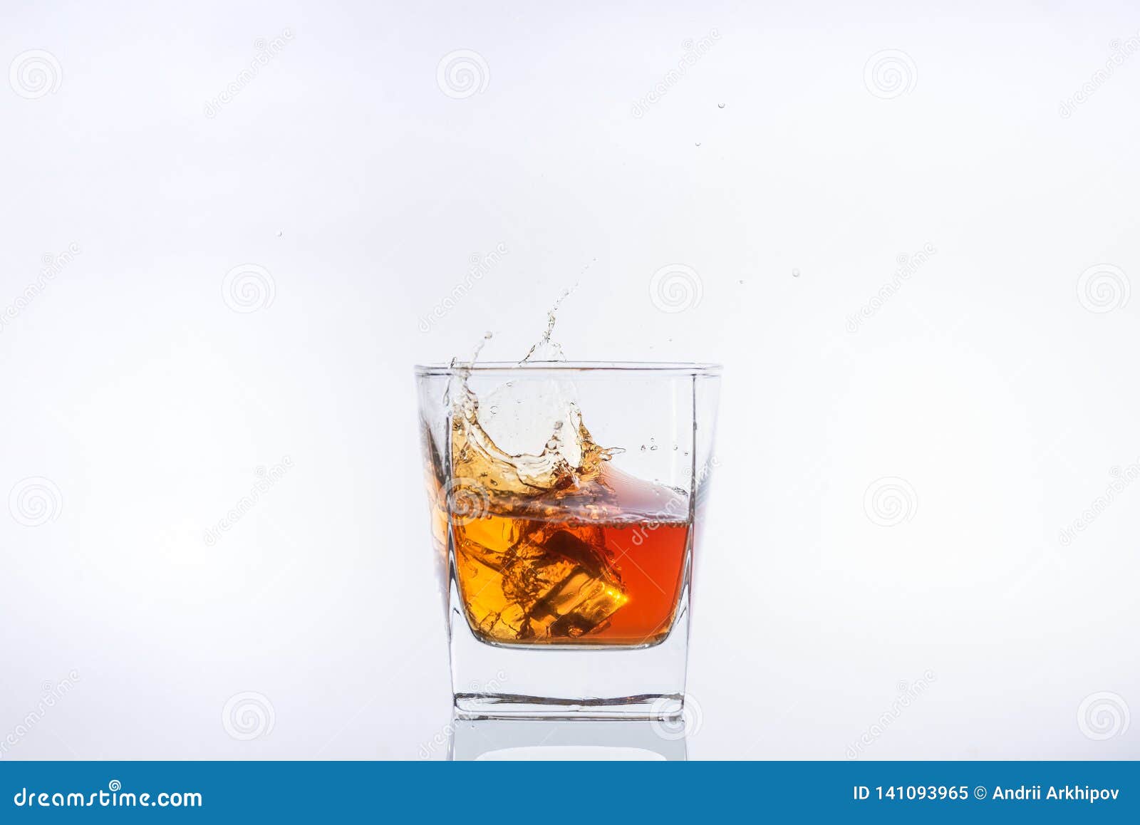 Premium Photo  Glass with whiskey and falling ice cube with splashes