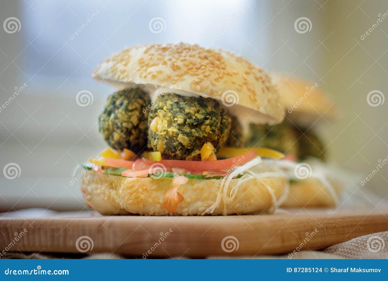 Alimentos de preparación rápida vegetarianos - hamburguesa del falafel en el tablero de madera