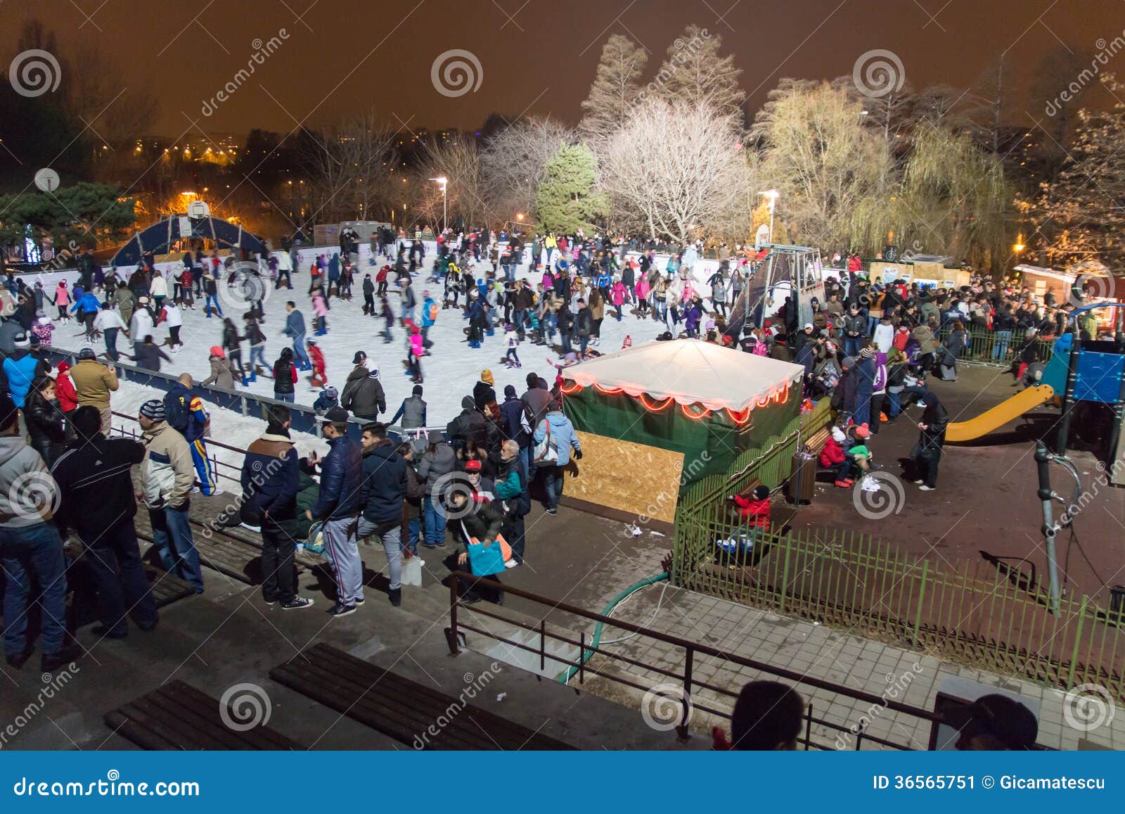 Alla pista di pattinaggio sul ghiaccio nella notte. Molta gente pattina sulla pista di pattinaggio sul ghiaccio nel parco della ricreazione di Alexandru Ioan Cuza a Bucarest, Romania