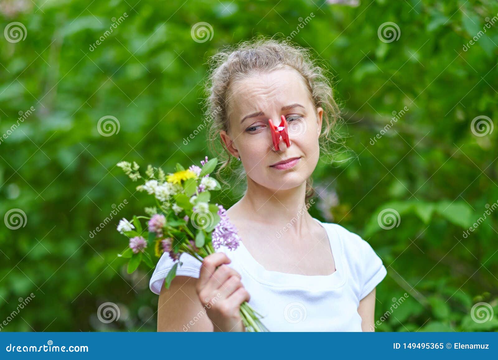 allergy. woman squeezed her nose with a clothespin, so as not to sneeze from the pollen of flowers